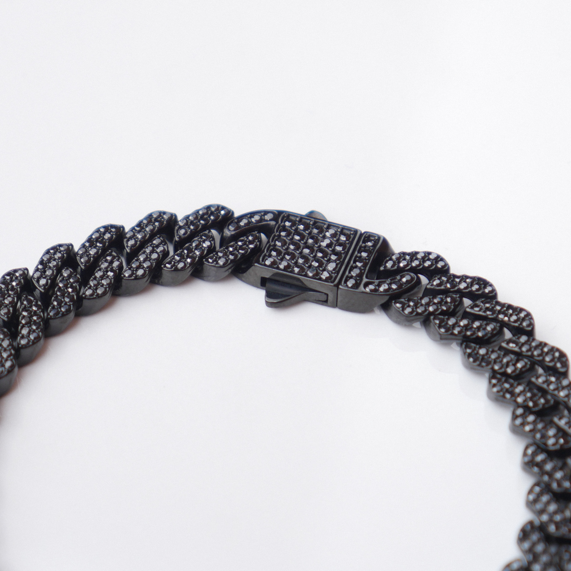A close-up of a black Cuban link chain bracelet with a matching black clasp, set against a plain white background.